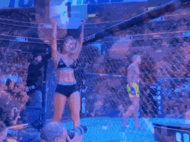 a girl in a bikini holds up a sign with the number 1 on it
