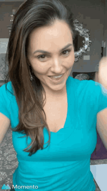 a woman in a blue shirt is taking a selfie in front of a momento icon