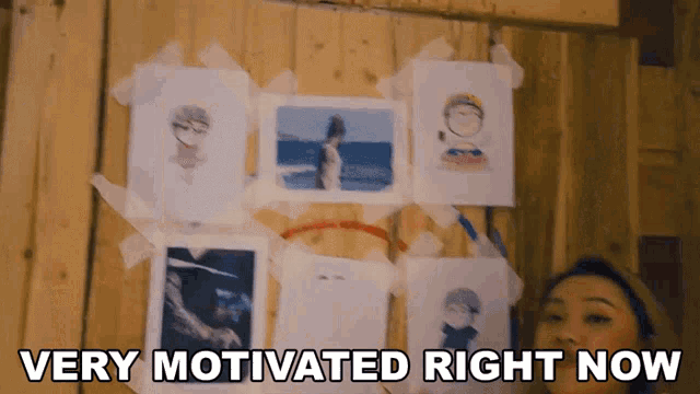 a woman is standing in front of a wall with pictures taped to it and the words " very motivated right now "