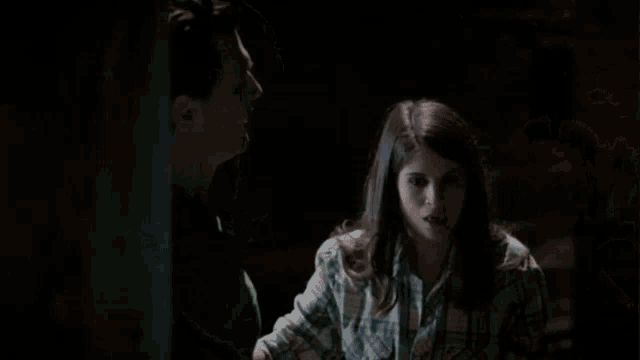 a man in a green shirt is clapping his hands in a dark room