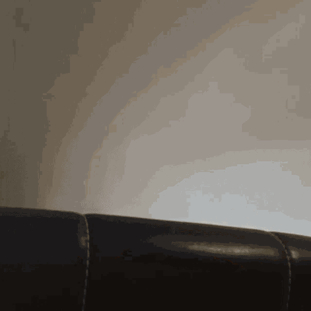 a close up of a couch with a white wall in the background