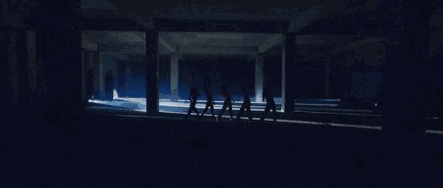 a group of people in white dresses are dancing in a dark room