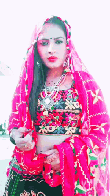 a woman is wearing a pink top and a red veil .