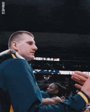 a man in a blue jacket with the word nuggets on the back