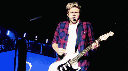 a man in a plaid shirt is playing an electric guitar