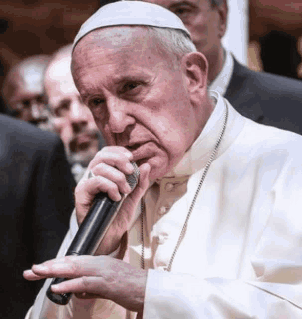 a close up of a man holding a microphone in his mouth .