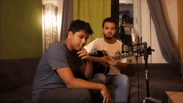 a man playing a guitar next to another man with the word nein on the bottom left