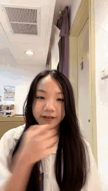 a young girl with long black hair is standing in a room