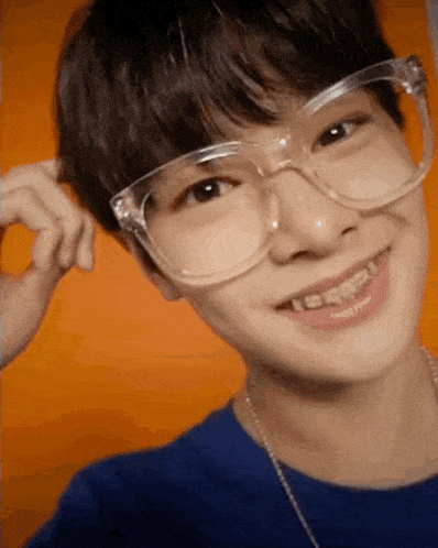 a close up of a young man wearing glasses and braces .