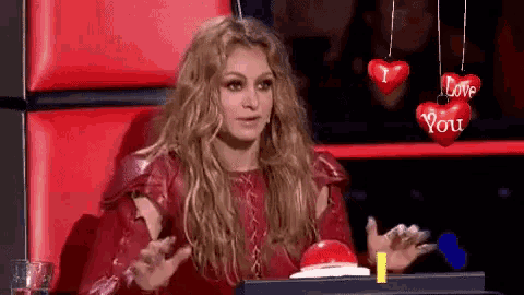 a woman is sitting in a chair with hearts that say i love you on them .