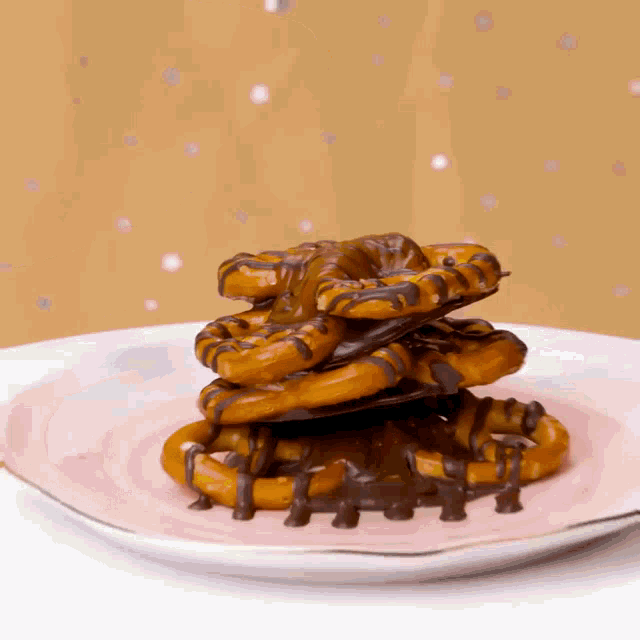 pretzels are stacked on top of each other on a pink plate