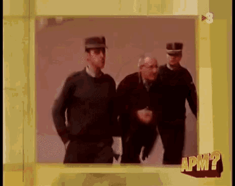 a man in a military uniform is being escorted by two men in uniform .