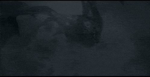 a black and white photo of a dragon flying through the sky .