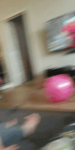 a pink balloon is being thrown on a table
