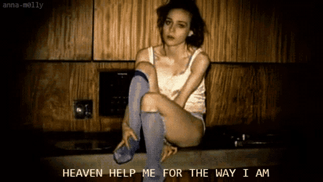 a woman sitting on a counter with the words " heaven help me for the way i am "