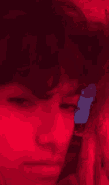 a blurry picture of a person 's face with a red background