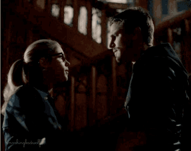 a man and a woman are looking into each other 's eyes in a dark room