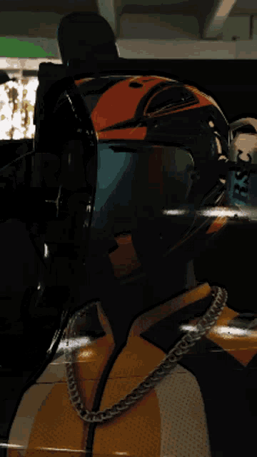 a close up of a person wearing a helmet and a chain around their neck