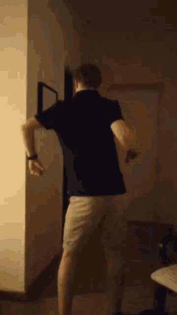 a man in a black shirt and white shorts is dancing
