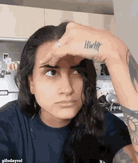 a woman with a tattoo on her wrist that says hwtf