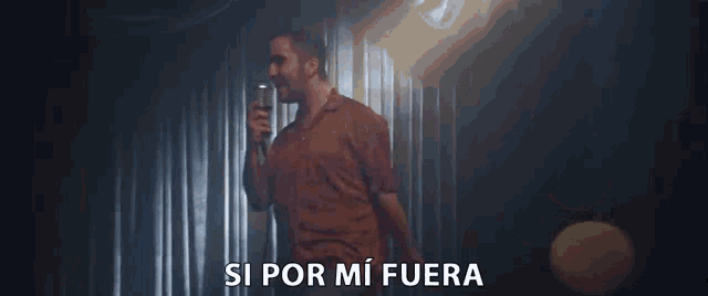 a man singing into a microphone with the words si por mi fuera written below him
