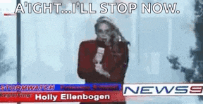 a woman is holding a microphone and talking on a cell phone in front of a news banner .