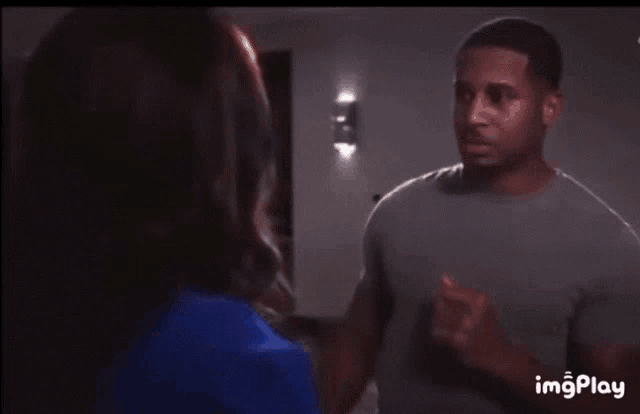 a man and a woman are looking at each other in a room .