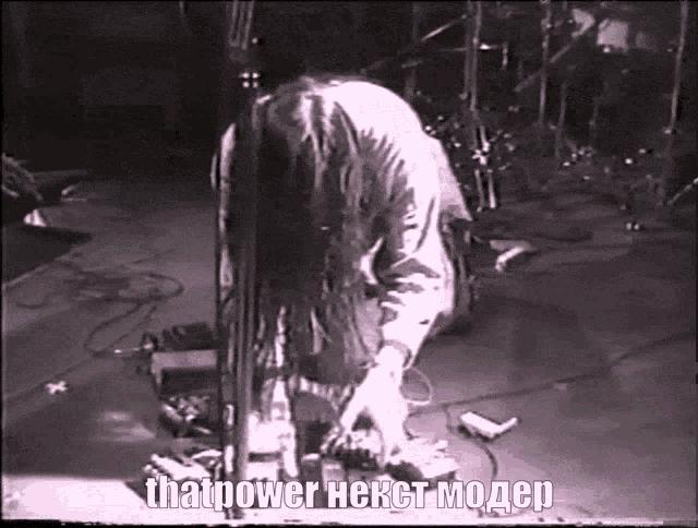 a black and white photo of a man playing a guitar with the words thatpower next modep written below him