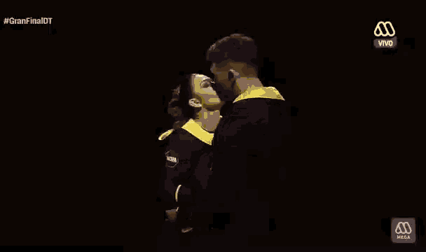 a man and a woman are kissing in front of a black background with the word vivo in the corner