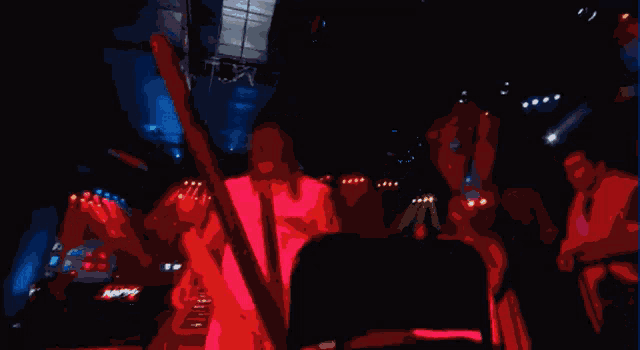a man in a red shirt is standing in a crowd