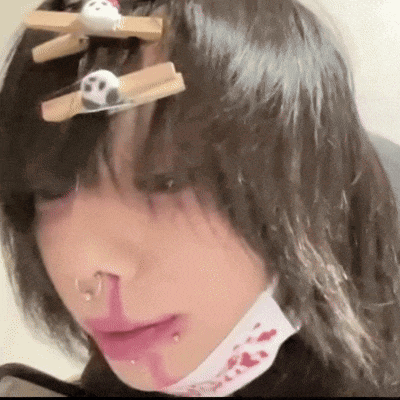 a close up of a person 's face with blood coming out of their nose and a panda hair clip .