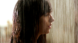 a woman standing in the rain with a tear running down her face