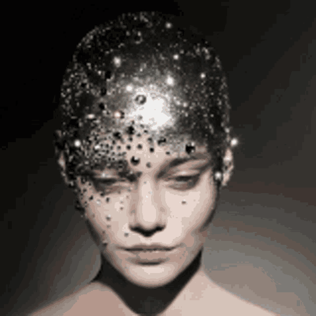 a close up of a woman wearing a silver headpiece