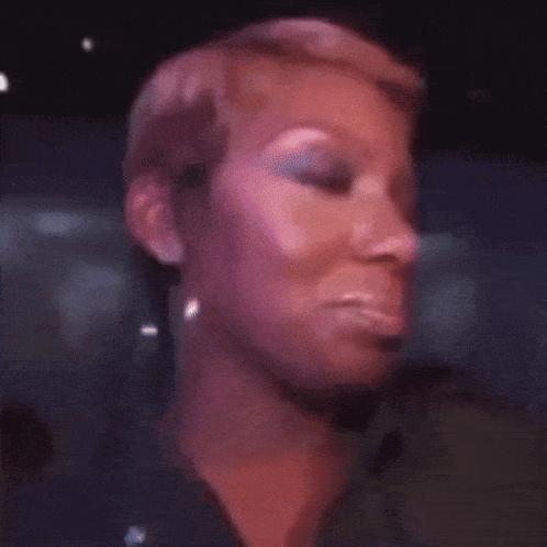 a close up of a woman 's face with short hair and makeup .