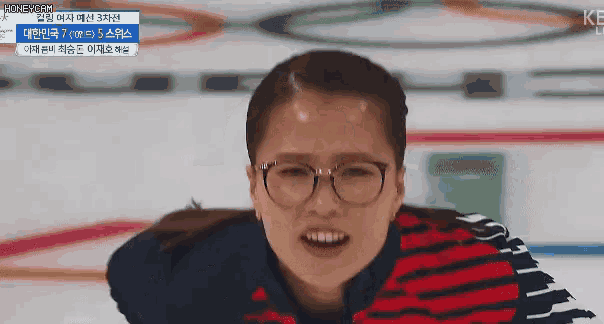 a woman wearing glasses and a striped shirt is smiling and looking at the camera .