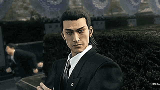 a man in a suit and tie is standing in front of a cemetery in a video game .