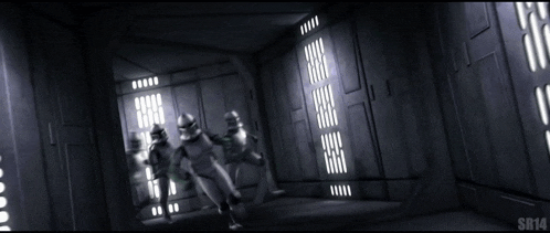 a group of stormtroopers are walking through a dark room
