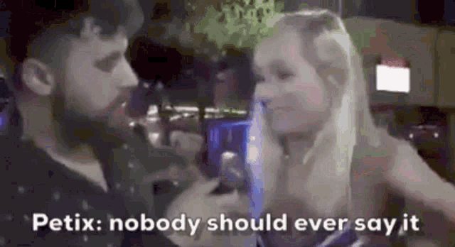 a man and a woman are talking to each other and the woman is holding a microphone .