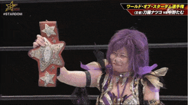 a woman with purple hair is holding a wrestling belt in front of a stardom logo