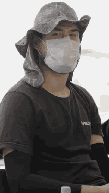 a man wearing a face mask and a hat with a hood