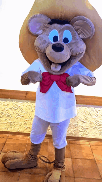 a mouse mascot wearing a white shirt and a red bow tie