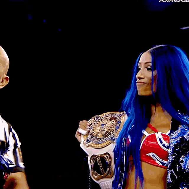a woman with blue hair is holding a wrestling belt