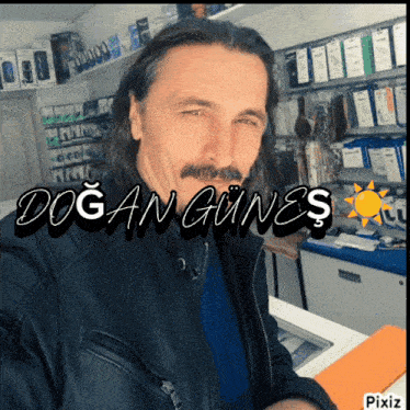 a man with long hair and a mustache is wearing a black leather jacket with the name doğan gunes on it
