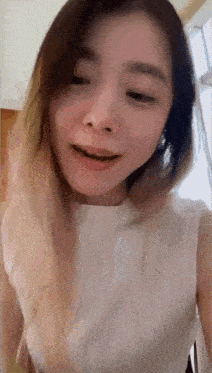 a close up of a woman 's face with a white shirt on .