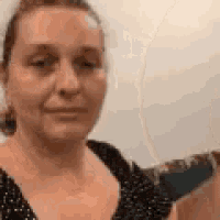 a close up of a woman 's face with a polka dot shirt on .