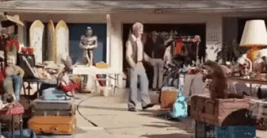 a man is standing in front of a garage filled with lots of stuff .