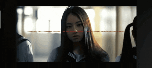 a girl with long hair looks at the camera