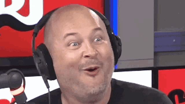 a bald man is wearing headphones and making a funny face