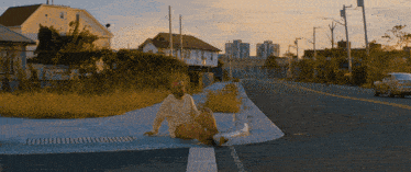 a man sits on the curb of a street corner