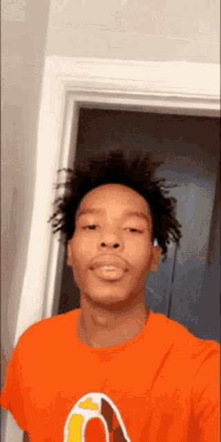 a young man wearing an orange shirt with the letter o on it